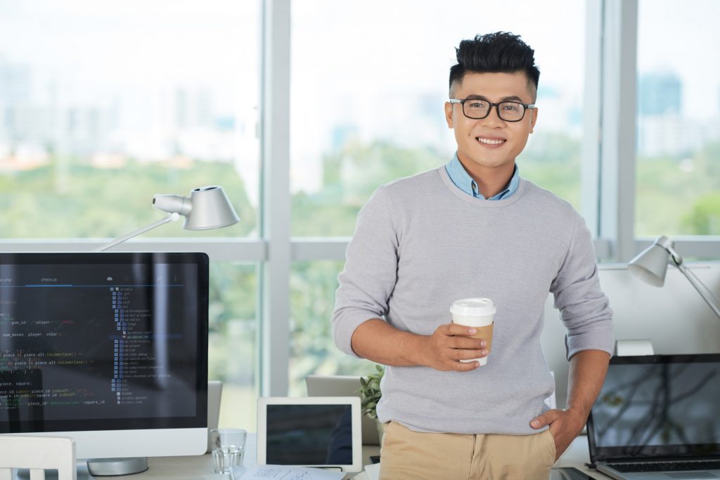 Asian man with drink in office